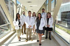 Seven IU School of Medicine students stand in a covered walkway on the IUPUI campus.
